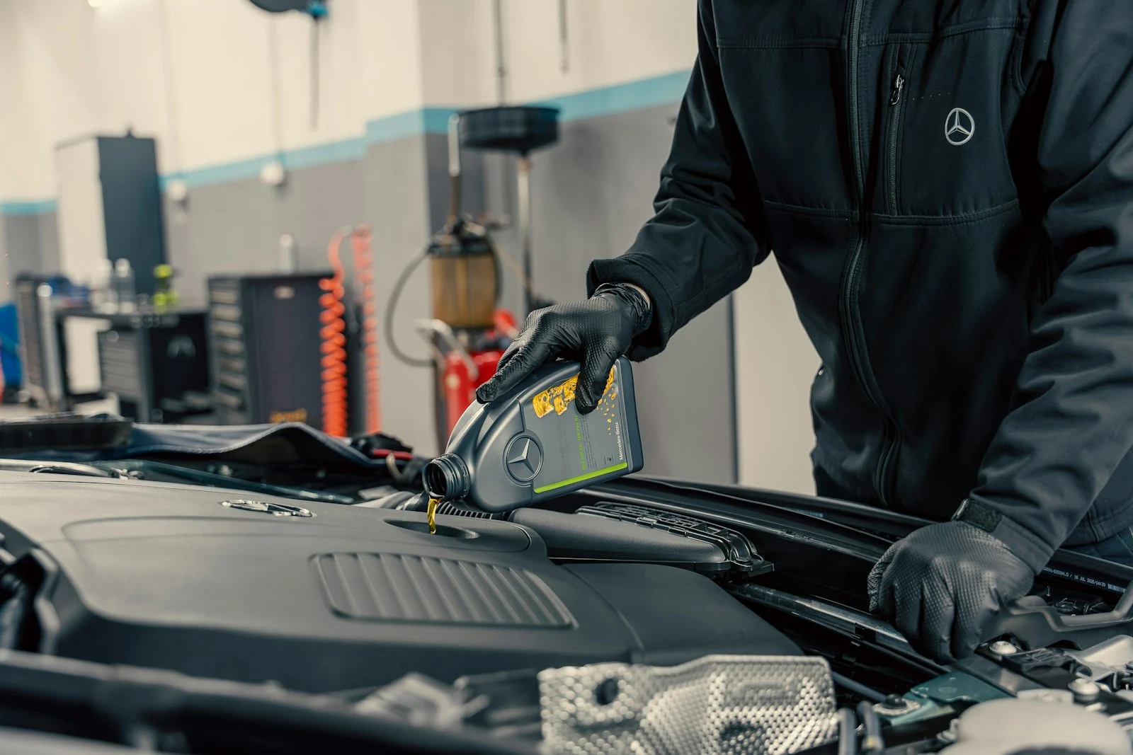 Mecánico rellenando el aceite del motor de un coche
